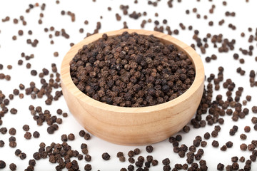 black peppercorns in wooden bowl