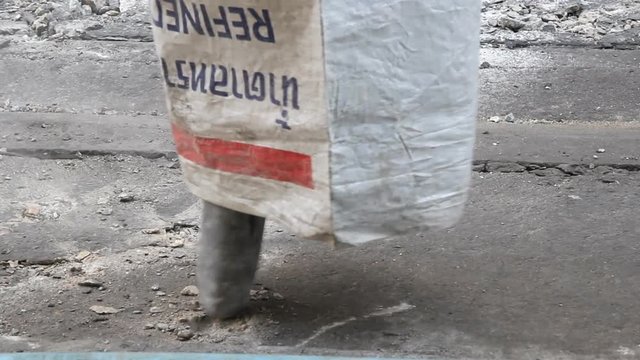 Hydraulic hammer demolishing concrete road