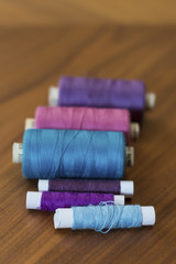 Spools of colorful silk thread on wooden background