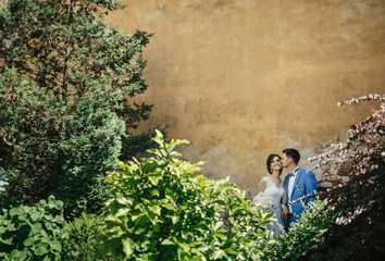 Brides kissing near wall