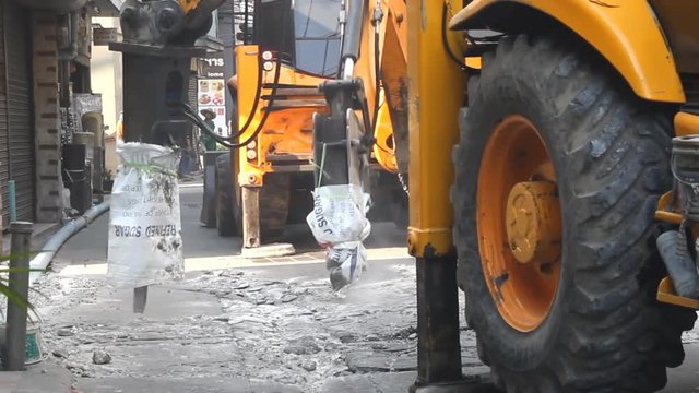 Hydraulic jack hammer is breaking concrete road