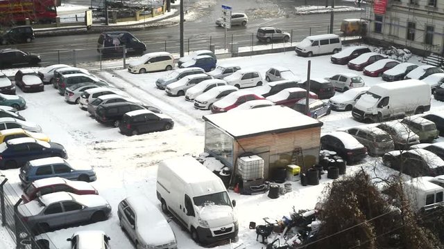 Cars in parking lot stuck under snow during freezing winter