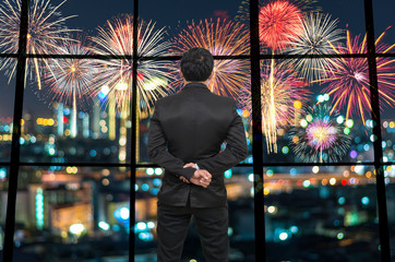 Back side of Businessman looking at Fantastic fireworks on the p