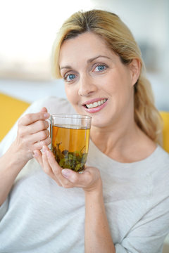 Portrait of blond woman drinking plants infusion
