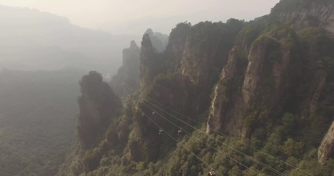 Aerial view of moving cable cars with mist in Tianmen mountain Zhangjiajie National Park, Hunan province, China.