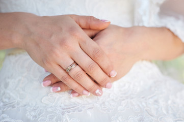 bride hand with a wedding ring on the background of dress