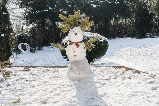 Snowman in the garden at first snow in the winter