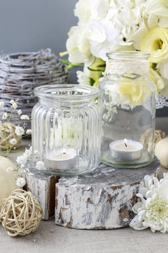 Wedding decoration with flowers and candles in glass jars.