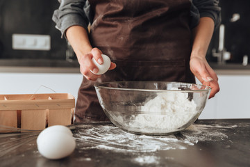 Cropped photo of young woman cooking the dough.