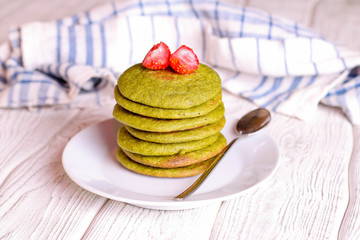 green pancakes on a white plate for breakfast, horizontal