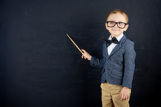 Little boy against blackboard. School concept