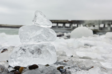chunks of ice stacked pyramid on the bank of the winter sea.
