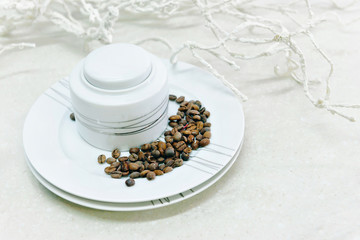 one white Cup and saucer, coffee beans in saucer