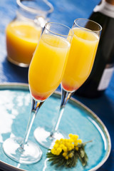 Two glasses with mimosa cocktail (sparkling wine plus orange juice)