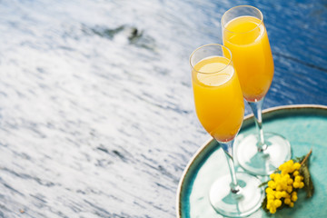 Two glasses with mimosa cocktail (sparkling wine plus orange juice)
