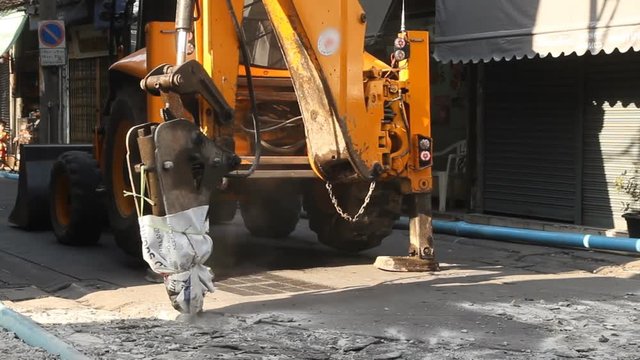 Hydraulic jack hammer is breaking concrete road
