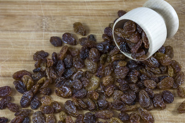 Wooden bowl with many brown raisins
