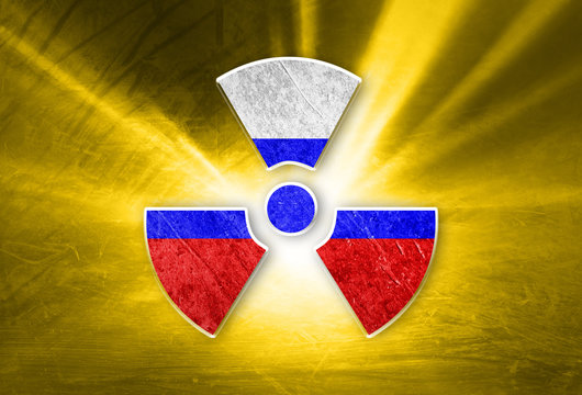 Conceptual shiny radioactive symbol with painted Russian flag on the grunge yellow colored illustration background.