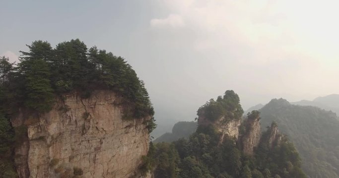 Aerial view of natural quartz sandstone pillar Avatar Hallelujah Mountain among green woods, mist,rocks in Tianzi Mountains, Zhangjiajie National Forest Park in Wulingyuan, Hunan Province, China.