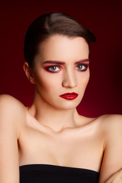 Portrait of beautiful sexy fashion model with red make up over r