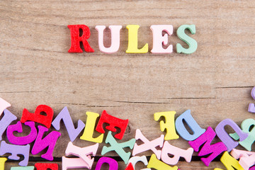 Text "RULES" of colored wooden letters on a wooden background