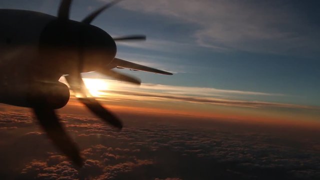 Propeller plane airplane sunset flying in sky, views from window evening flight	