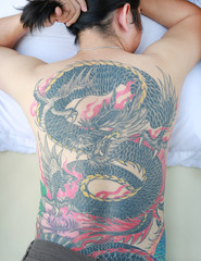Man with tattoo dragon on his back.