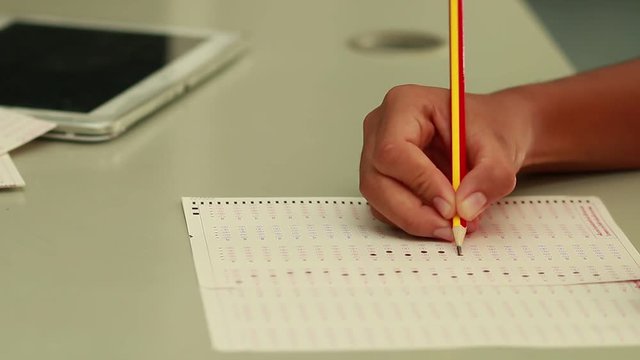 Student filling Optical mark recognition out or answer sheets for test in classroom