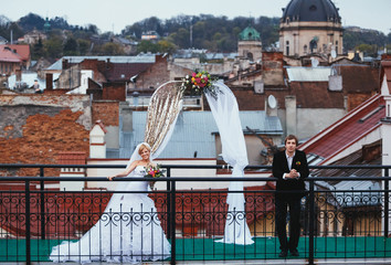 couple on the roof near the arch