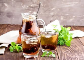 Ice tea with berry and fresh mint in glasses Wooden background