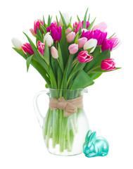 bunch of fresh purple, pink and white tulip flowers in glass vase with rabbit isolated on white background