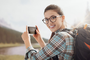 Woman taking nature photos with her phone