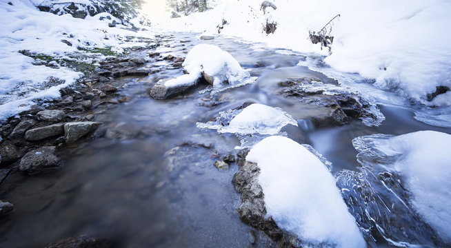 Winter landscape with frozen mountain creek