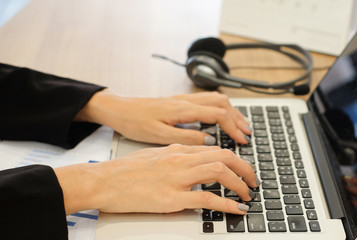 close up work woman writing on paper and typing on laptop in office room,student girl doing homework or lecture lesson or researching about project:busy people:vintage mood tone color effect.hard work
