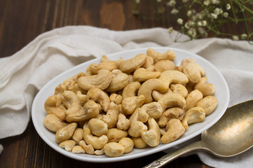 cashew on white dish on wooden background