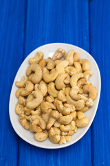 cashew on white dish on wooden background