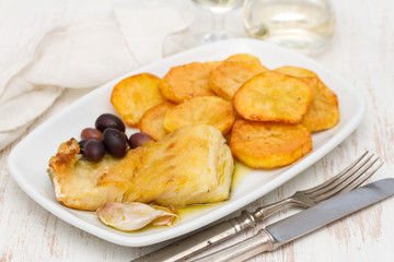 fried cod fish with potato on white dish