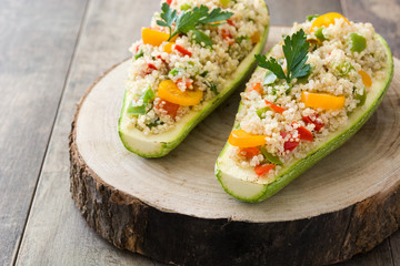 Stuffed zucchini with quinoa and vegetables on wooden background
