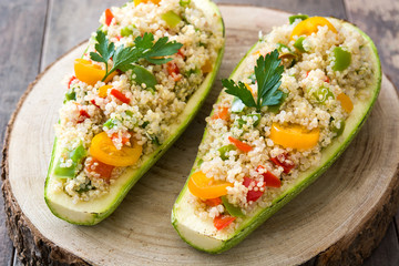 Stuffed zucchini with quinoa and vegetables on wooden background
