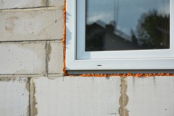 Windows installation and insulation in new house construction building.