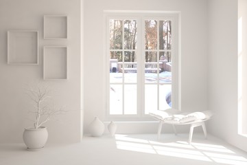 White room with chair and winter landscape in window. Scandinavian interior design