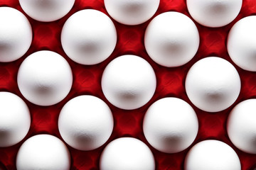 White eggs pattern in red color carton pack direct above view
