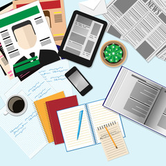 Top view of workplace with computer devices, magazines, newspape