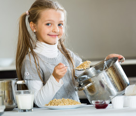 Sweet girl preparing oatmeal for breakfast in kitchen