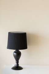 black lamp on white table and yellow wall as background, concept