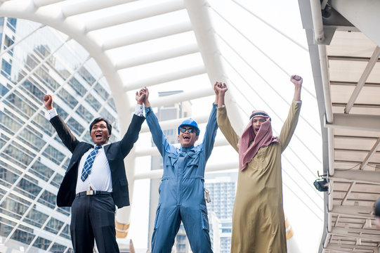 team of multi-ethnic businessmen working together to raise their hands over the head shows the joy of team success.