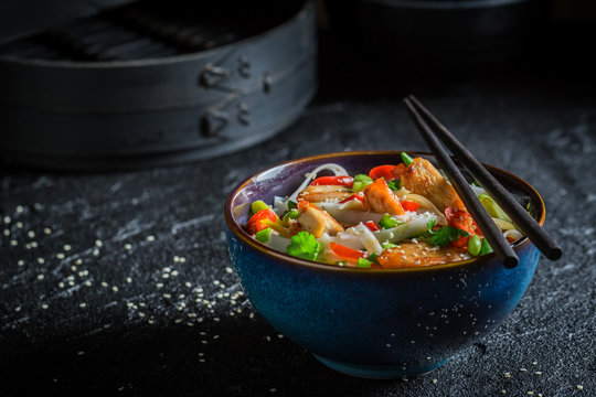 Tasty noodle in dark bowl with chopsticks
