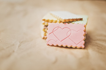 Sweet colored cookies stacked on brown paper
