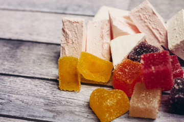 marshmallow multicolored marmalade in sugar on a wooden background