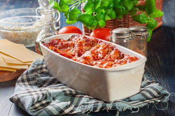 Hot tasty lasagna with spinach in ceramic casserole dish